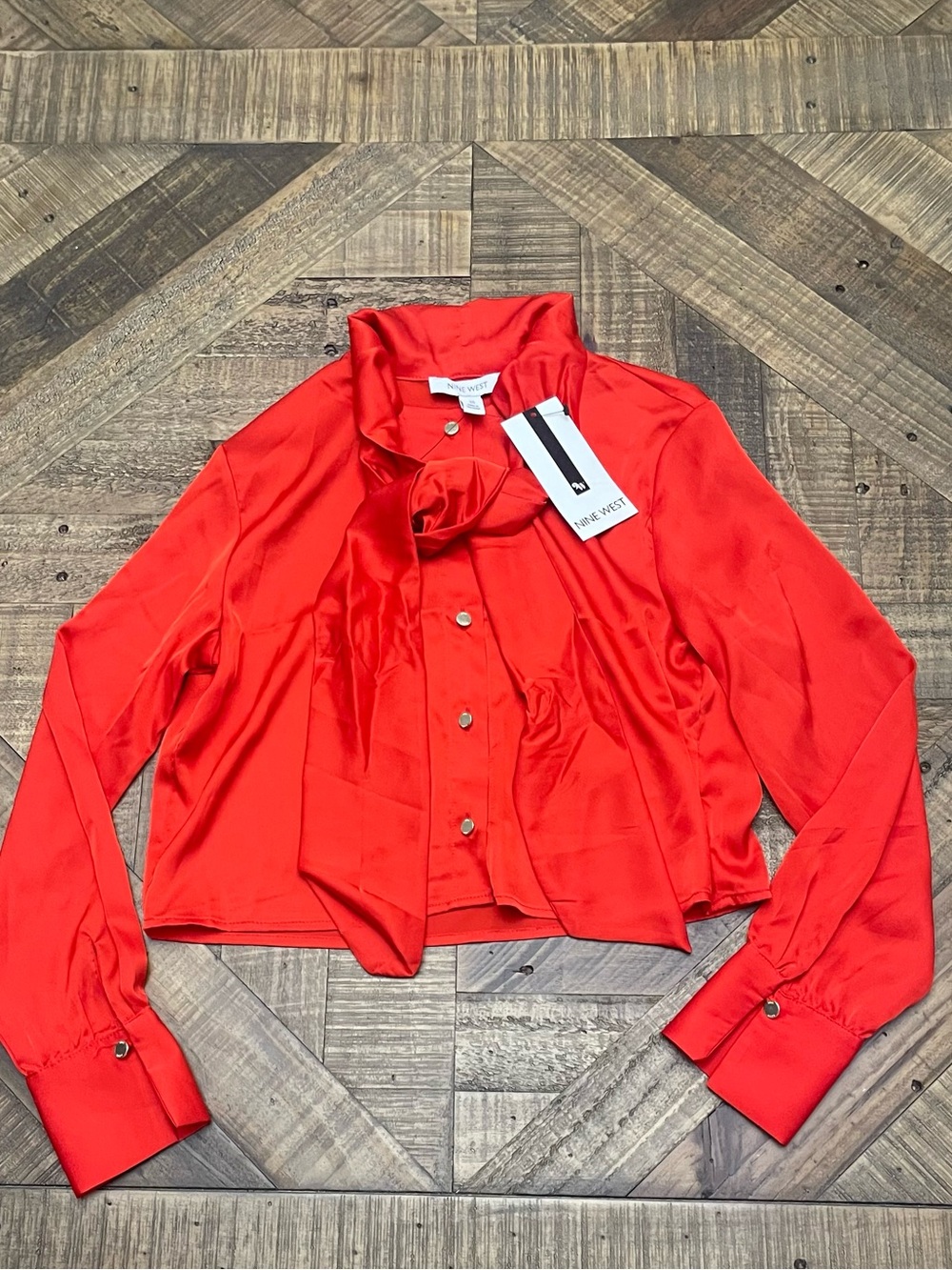 Nine West blouse is a vibrant red satin top featuring a dramatic tie-neck detail